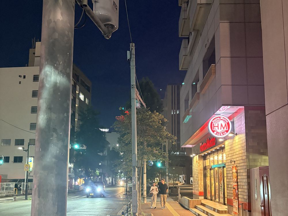 夜の交差点。右手にほっともっとの看板が点灯している